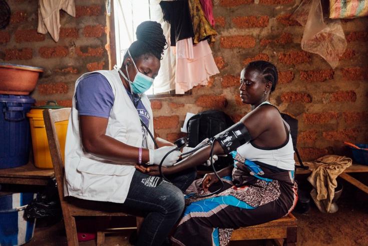 Enfermera tomando la presión arterial de una mujer en Sierra Leona