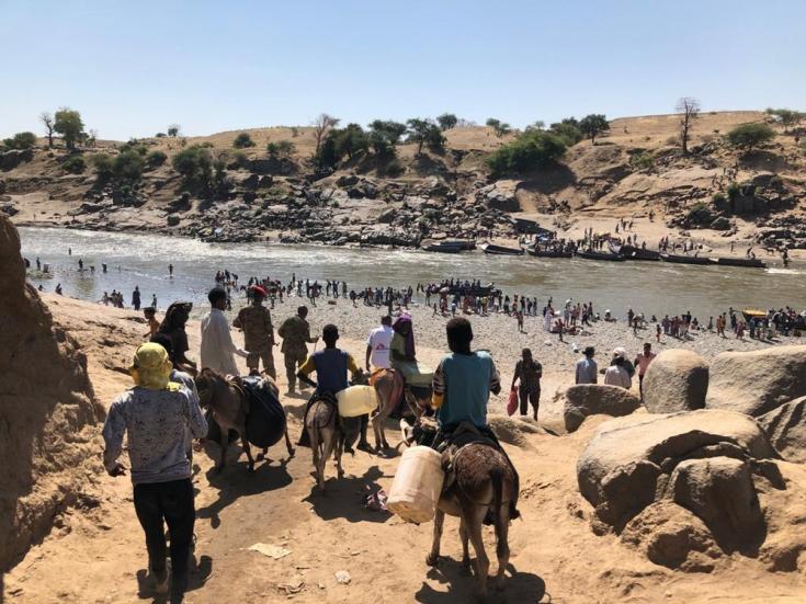 El paso fronterizo de Hamadayet, donde refugiados de Etiopía cruzan el río hacia Sudán. Los recién llegados se llevan todas las pertenencias que pueden llevar consigo, algunos se quedan con el ganado y otros sin nada.