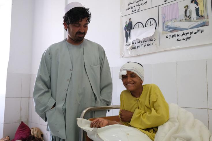 Samiullah, de 12 años, sonríe junto a su tío Ahmadullah en el hospital de Boost, tras haber recibido atención por una herida de bala que recibió en la cabeza el 4 de mayo. Afganistán, mayo de 2021
