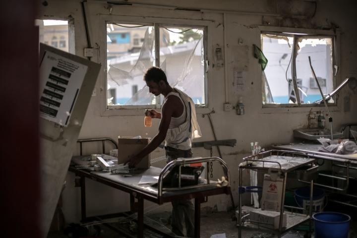 Un trabajador del hospital rescata los restos no dañados de medicamentos y equipos que quedaron en la sala de emergencias después del ataque aéreo de la coalición liderada por Arabia Saudita el 15 de agosto, que destruyó el hospital y mató a 19 personas.