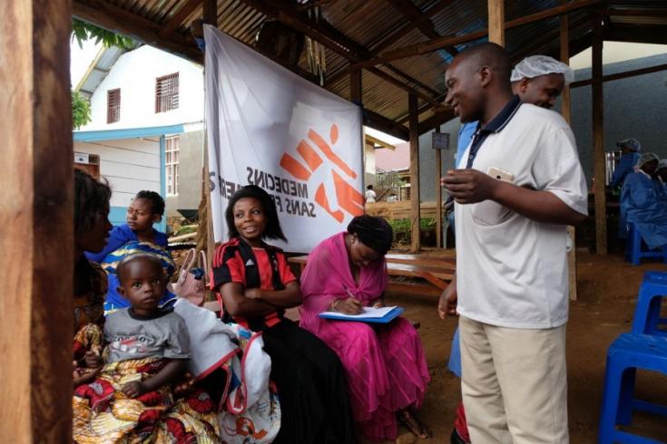 El trabajador sanitario Joseph habla con las personas que esperan recibir la vacuna en República Democrática del Congo.