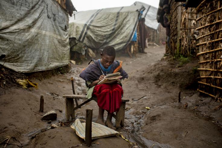 Una niña de 12 años en el campo de desplazados internos de Katale, en el territorio de Masisi. Hace su tarea durante las últimas horas del día, frente a su casa.