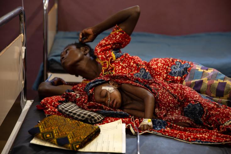 Con apenas dos años y medio de edad, Ester recibe tratamiento en la Unidad de Cuidados Intensivos de la sala de sarampión de MSF. Su madre Evelyne está acostada a su lado, en el Hospital Bossangoa, República Centroafricana.