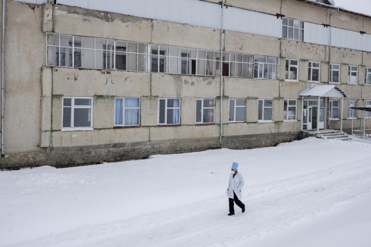 Un médico del Ministerio de Salud local camina frente al hospital Aydarken en la región suroeste de Kadamjay de Kirguistán.