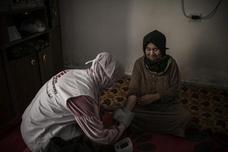 Hala, enfermera, midiendo la presión arterial de Maryam durante una visita a domicilio. Maryam es una mujer siria de 90 años sufre ceguera pero también diabetes e hipertensión. Burj al-Barajneh, Beirut, Líbano.